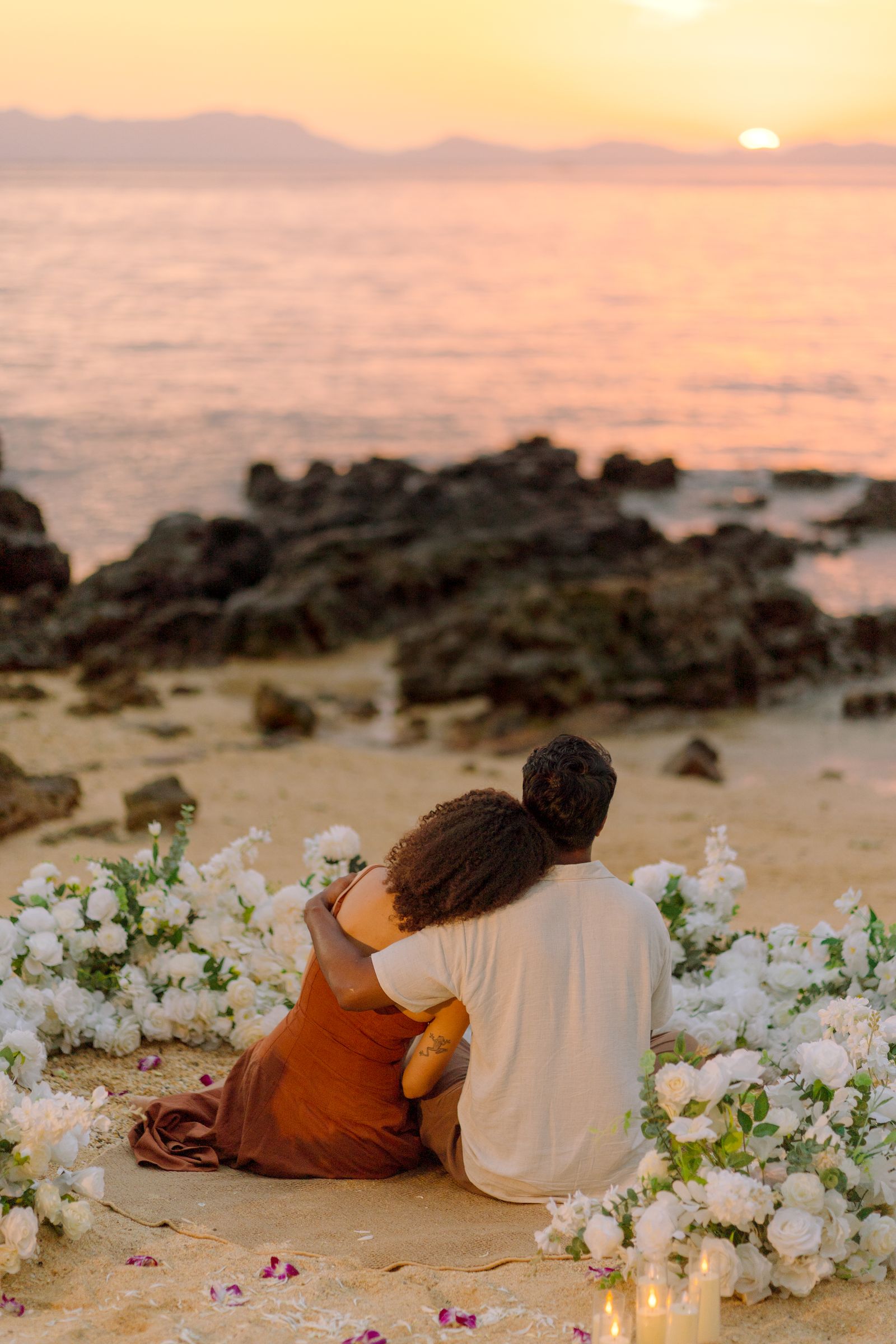 Larissa and Nihal sitting together surrounded by flowers