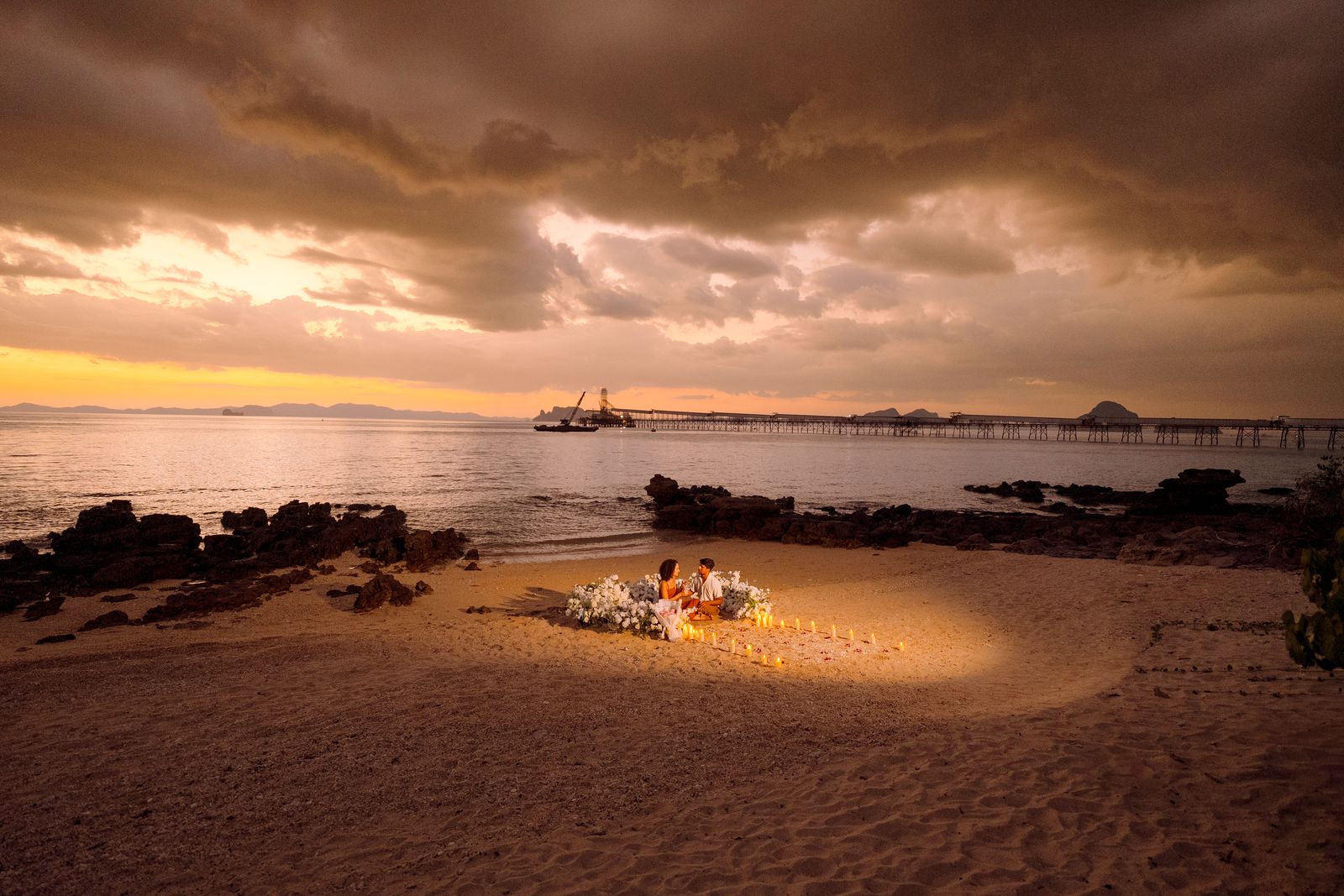 Larissa and Nihal's candlelit proposal setup on the beach